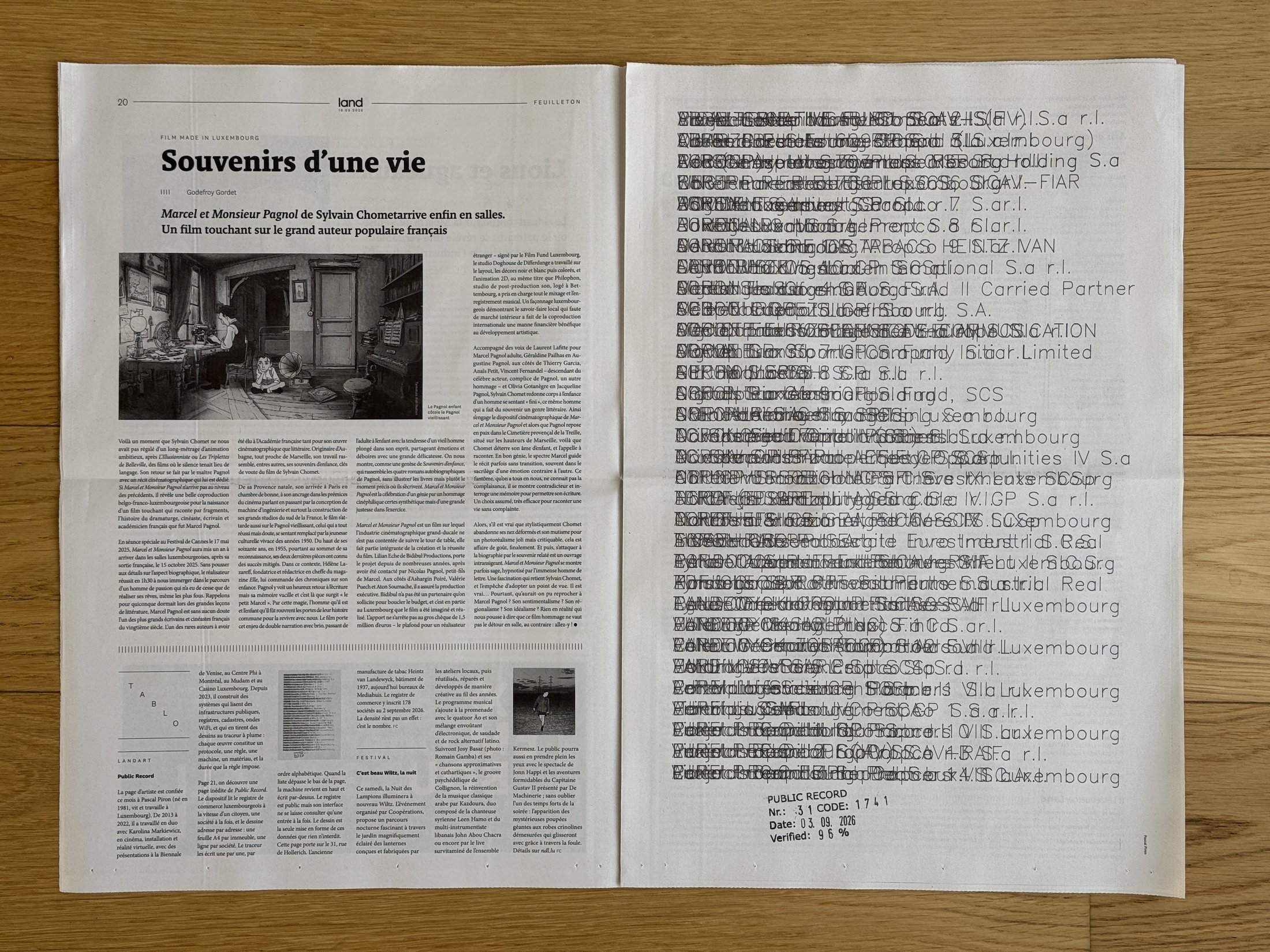 d'Lëtzebuerger Land of 18 September 2026 open on a wooden floor: page 20 with the Land Art box on the left, page 21 filled by the Public Record sheet on the right.